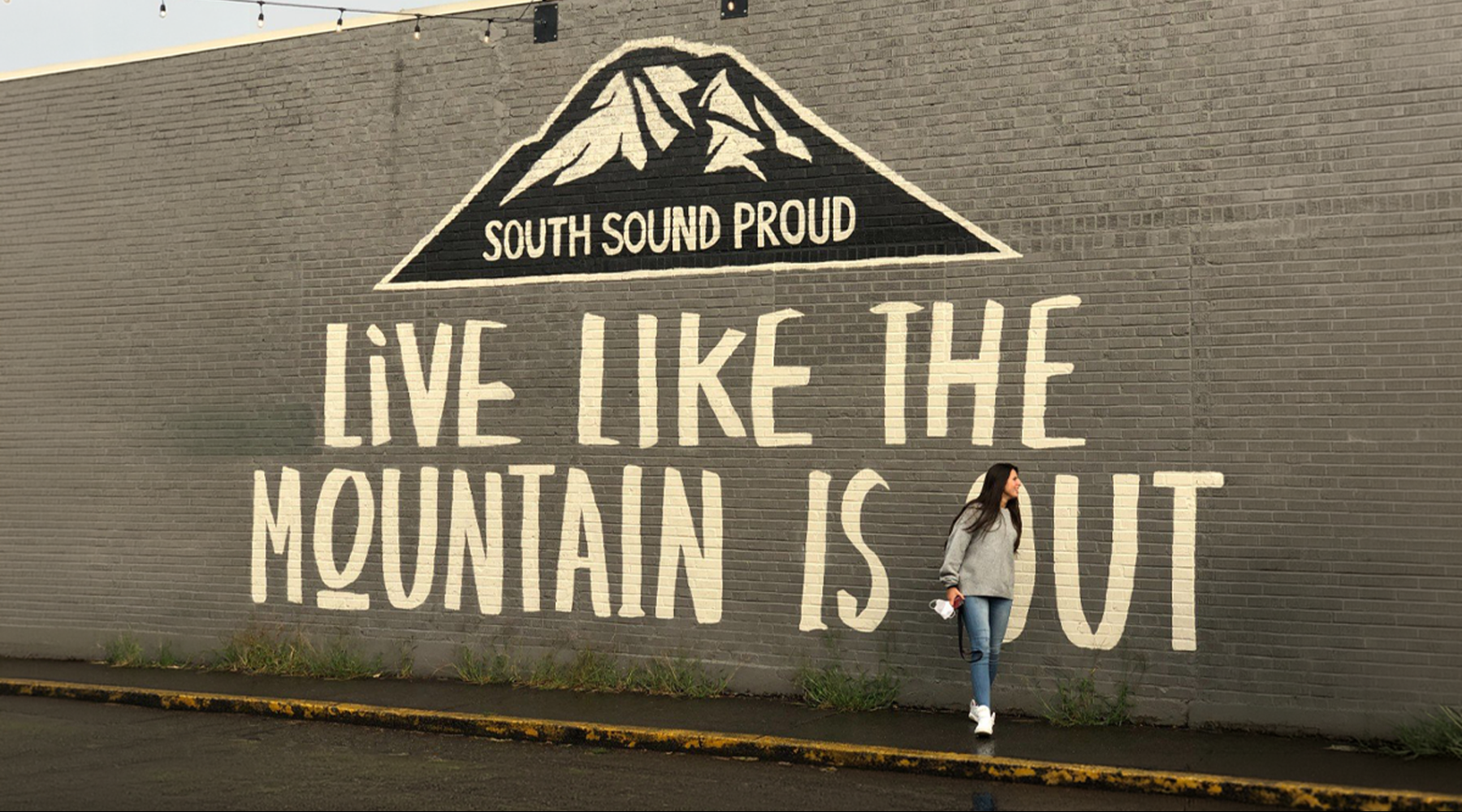 a woman standing in front of a painted wall